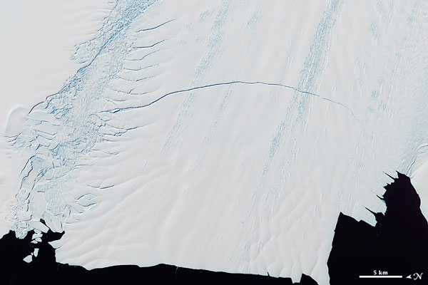 A imagem fascinante feita pelo sensor ASTER, satélite Terra, NASA, no dia 13 de novembro revela a enorme rachadura que se formou no glaciar Pine Island no Oeste do continente antártico. A rachadura de 19 km de extensão levantou mais uma vez preocupações sobre o ritmo de derretimento das calotas polares. O Pine Island reduz 100 metros sua extensão a cada ano.